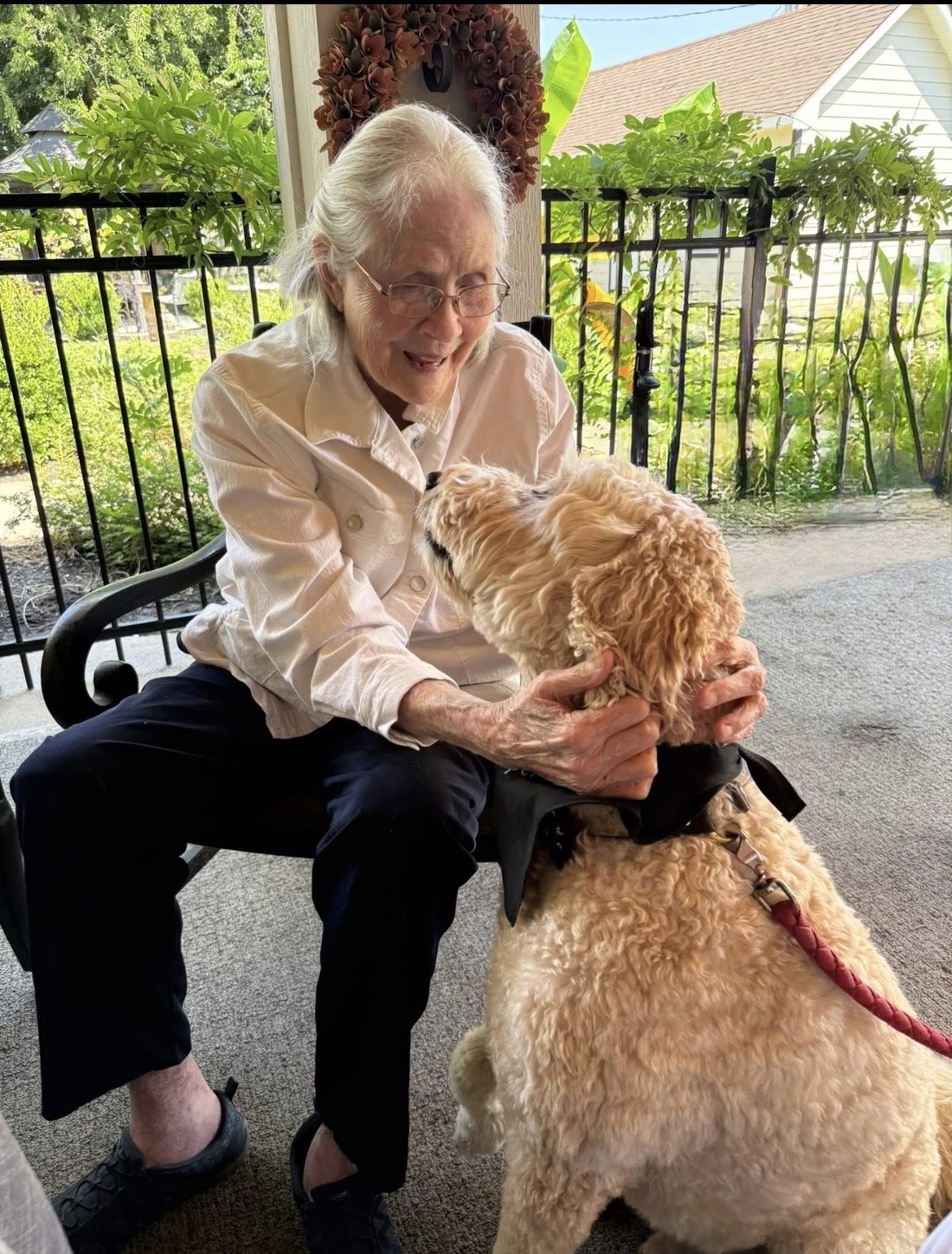 Resident petting a visiting dog outdoors