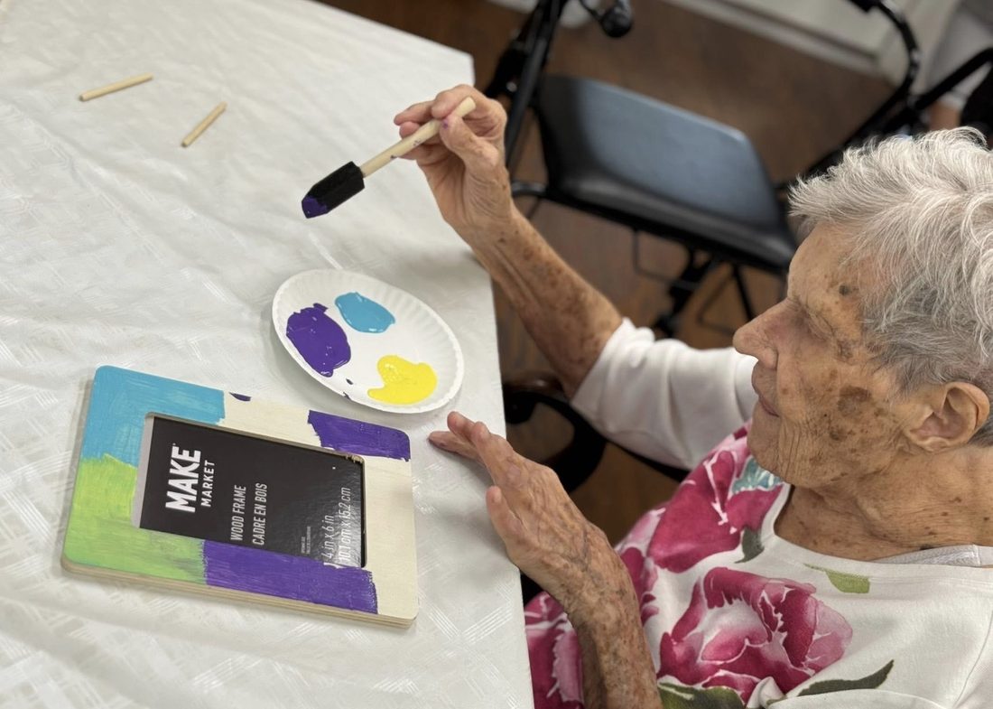 Resident painting a wooden keepsake frame