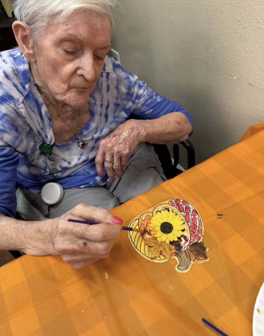 Resident painting a fall craft project